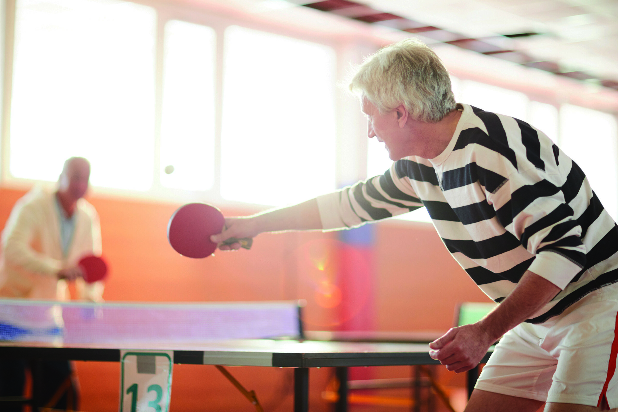 Seniors playing ping pong as an example of embracing play to promote mental and spiritual well-being