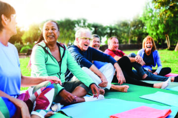 Group of older adults participating in a fitness class at a senior center, enjoying social connection and wellness activities.