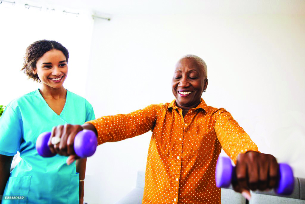 Occupational therapist assisting a senior with mobility exercises, helping improve daily living skills and independence.